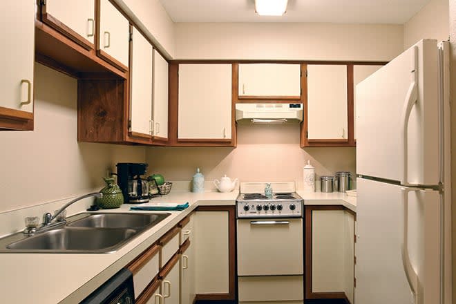 A compact kitchen with beige cabinets and modern appliances.