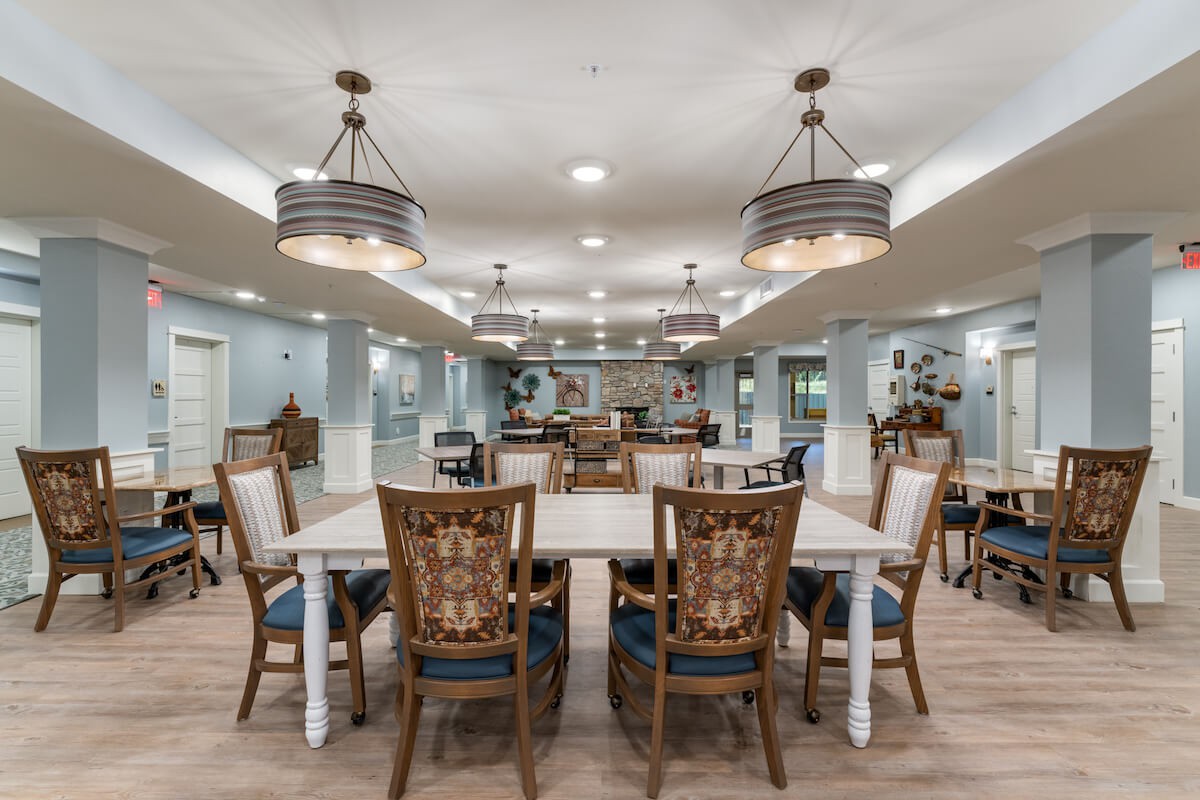A modern dining area featuring elegant chandeliers and wooden furniture.