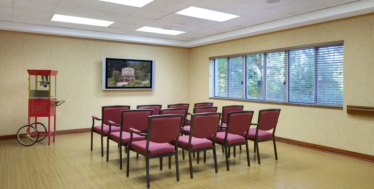 A conference room with rows of chairs facing a television.