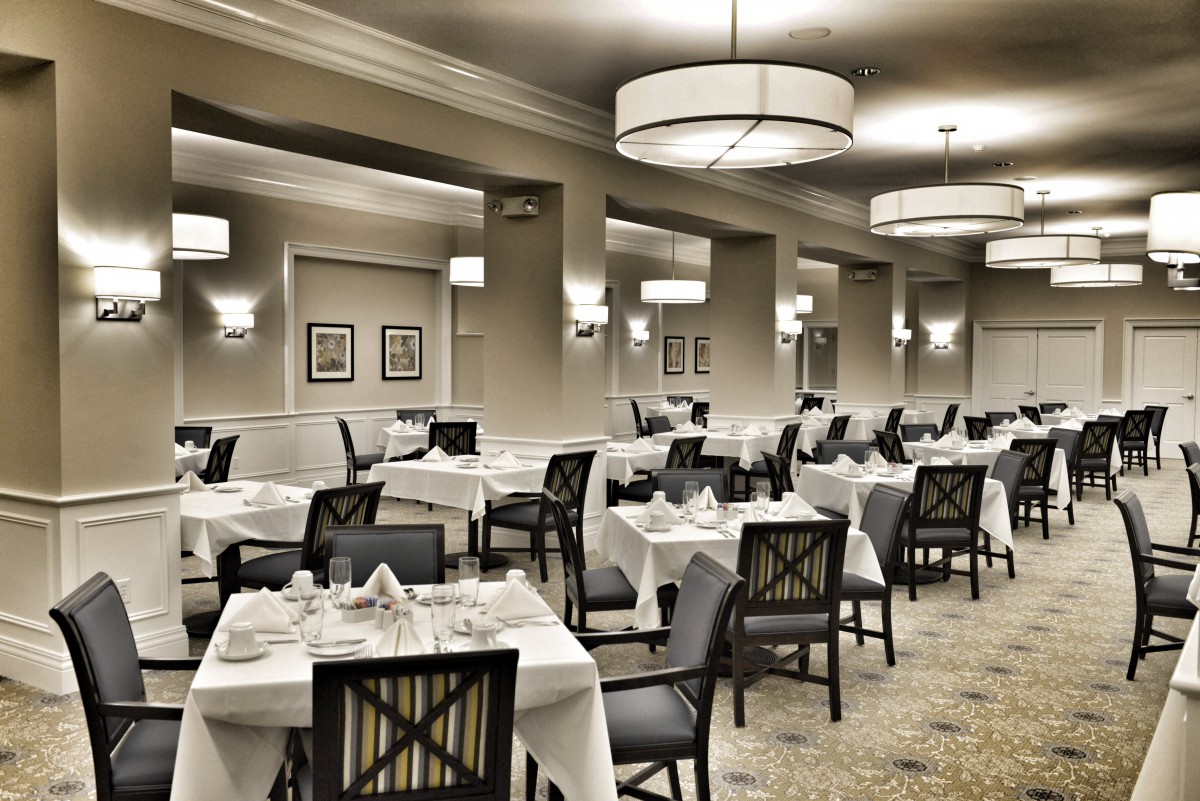 An elegant restaurant dining room with neatly arranged tables and sophisticated lighting.