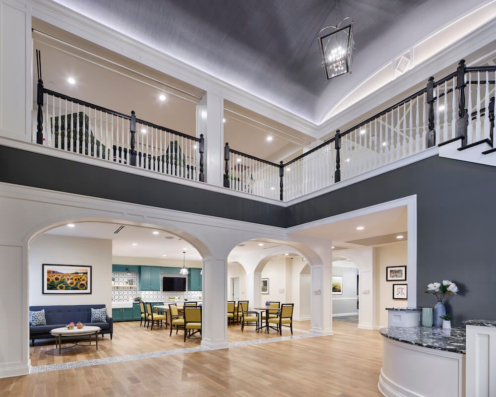 A spacious and modern interior featuring a dining area, balcony, and stylish lighting.