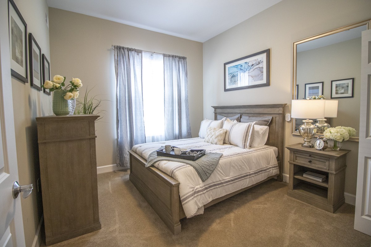 A cozy bedroom with a neatly made bed and soft lighting.