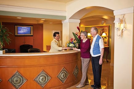 Guests checking in at a hotel reception desk.