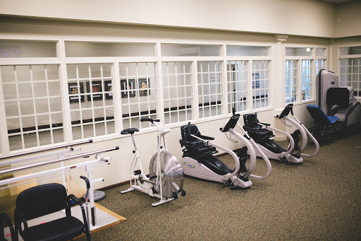 A well-equipped gym area featuring various exercise machines, ideal for fitness and rehabilitation.