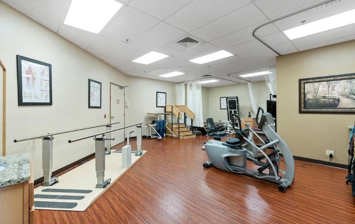 A rehabilitation room equipped with various exercise machines and therapy tools.