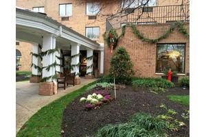 A building adorned with holiday garlands and wreaths, surrounded by well-maintained landscaping.