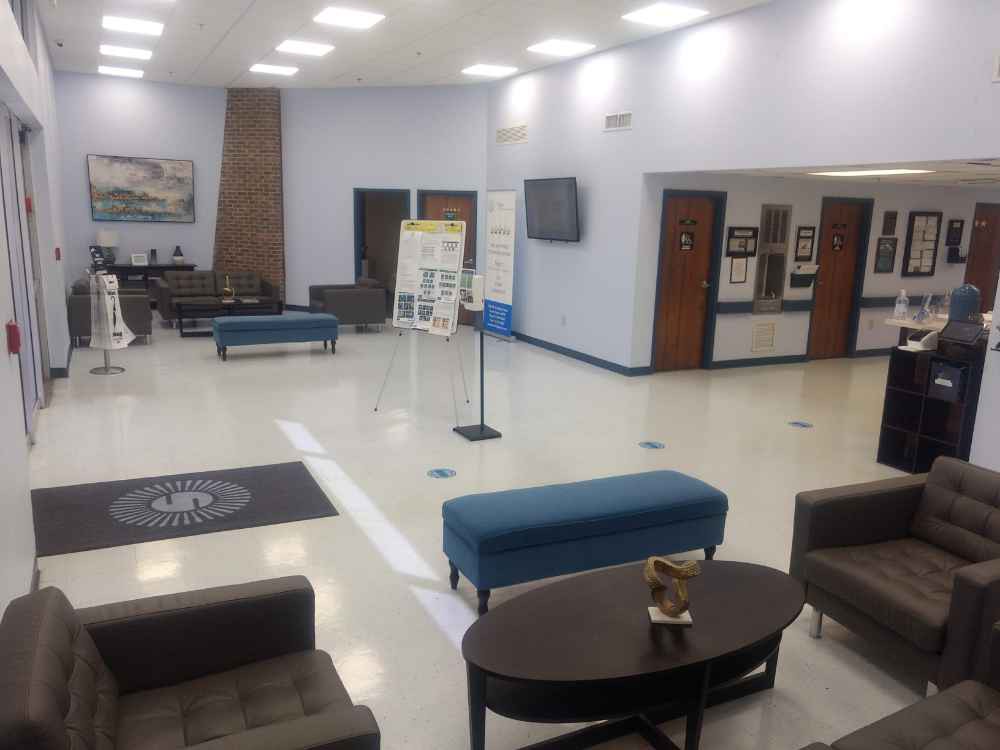 A spacious lobby area with seating and a reception desk.