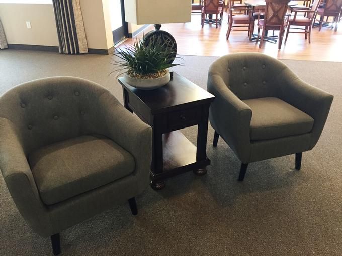 A cozy lobby area with two armchairs, a small table, and decorative elements.