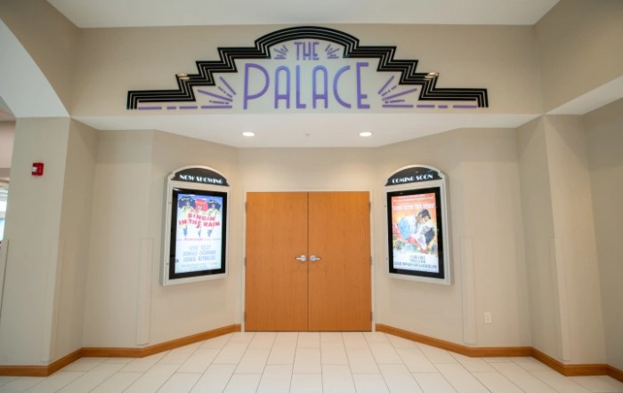 Art Deco-style entrance of The Palace cinema with movie posters on either side.