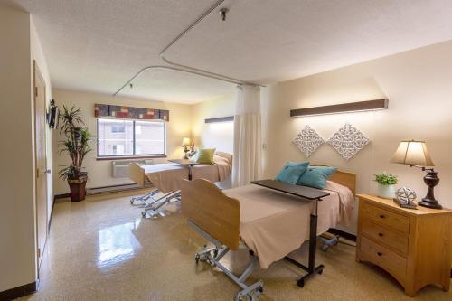 A well-lit patient room featuring two hospital beds, with a warm and inviting atmosphere.