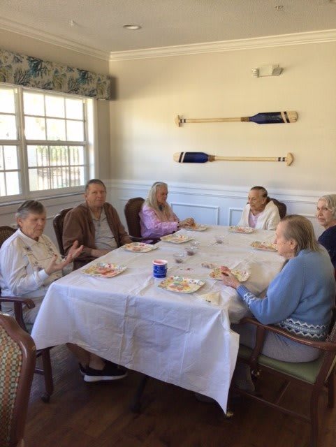 A group of elderly individuals enjoying a meal together indoors.