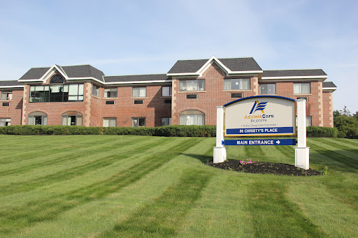 A well-maintained hotel exterior with landscaped grass in front.