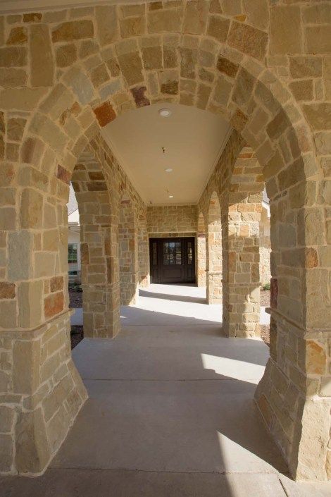 A stone archway corridor with columns and a covered walkway.