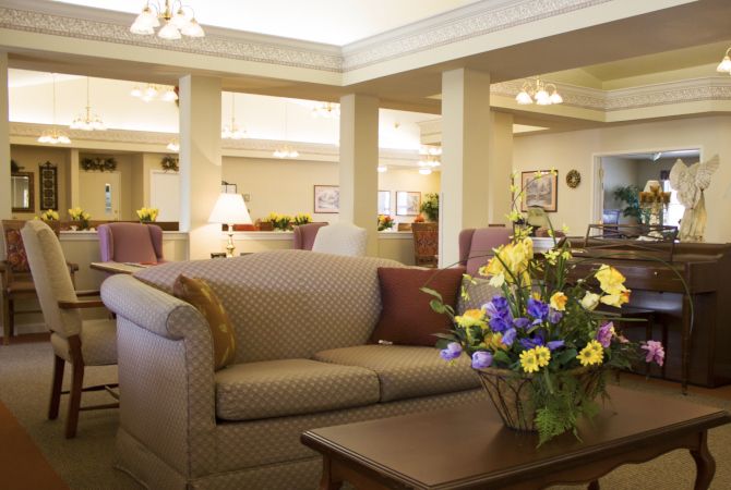 A cozy living room interior with a sofa and a coffee table adorned with a vibrant floral arrangement.