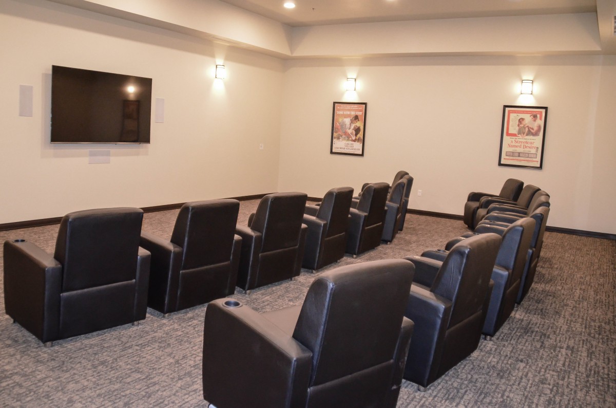 A cozy home theater with comfortable recliner seating and a large screen.