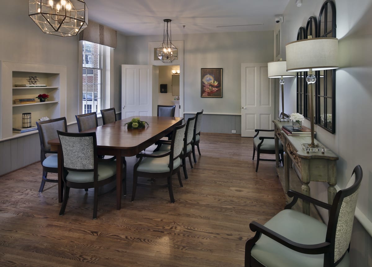 Elegant dining room with a large table, comfortable chairs, and stylish chandeliers.