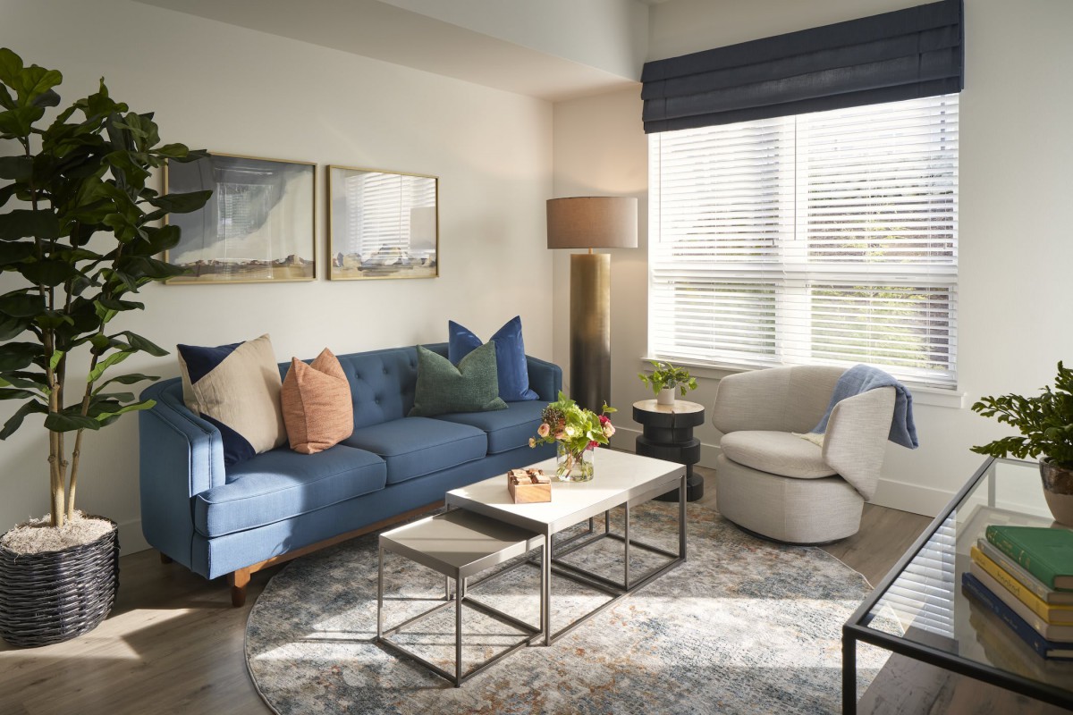 A modern living room with a blue sofa, stylish coffee table, and decorative accents.