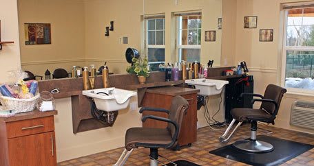 A cozy hair salon interior with styling chairs, mirrors, and washing sinks.