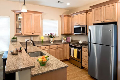 A modern kitchen featuring warm wood cabinets, stainless steel appliances, and a beautiful granite countertop.