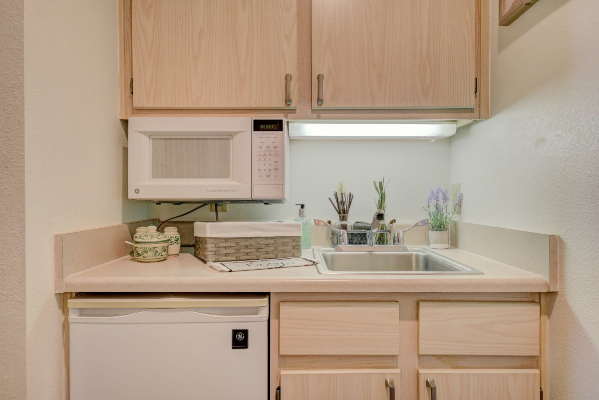 Compact kitchen setup with a microwave, sink, and countertop.