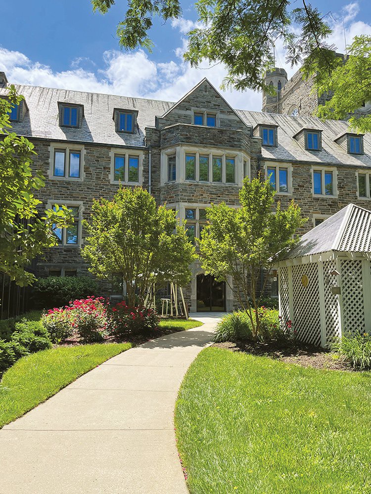 A charming building with stone architecture and a landscaped garden.