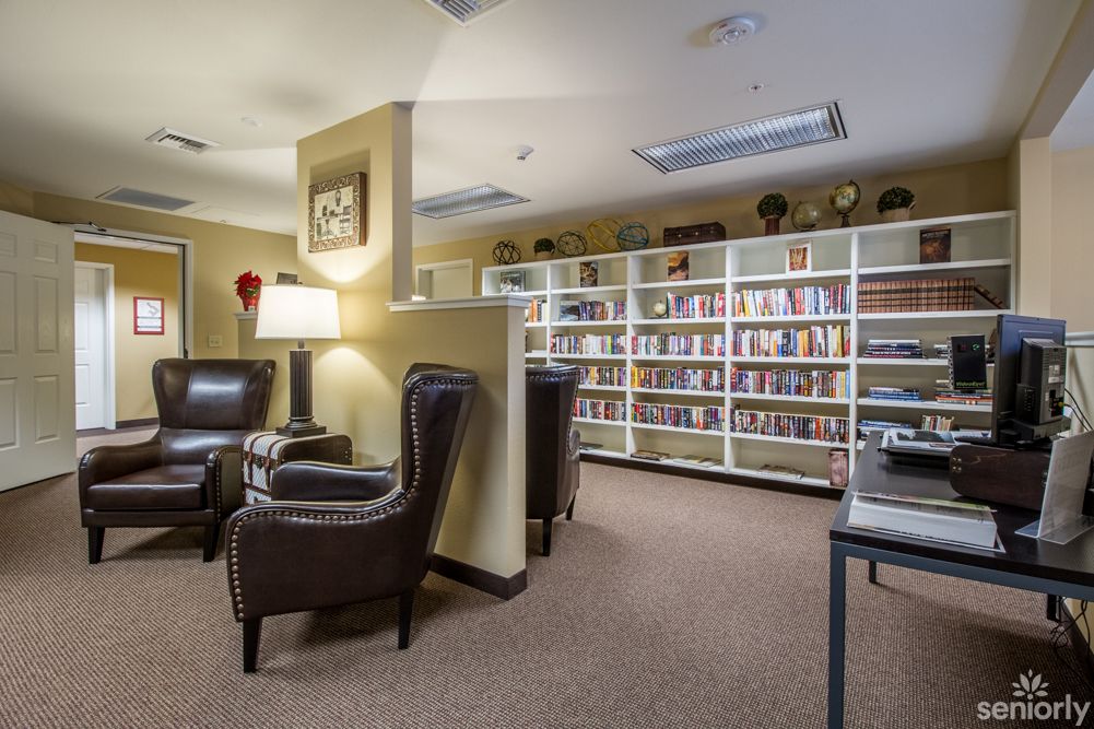 A cozy library reading area with bookshelves and comfortable seating.