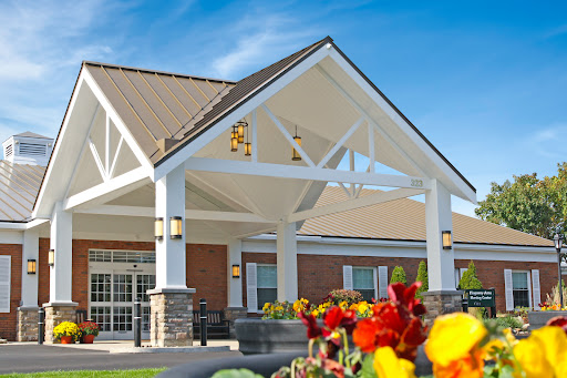 A beautifully designed community center entrance surrounded by vibrant flowers.