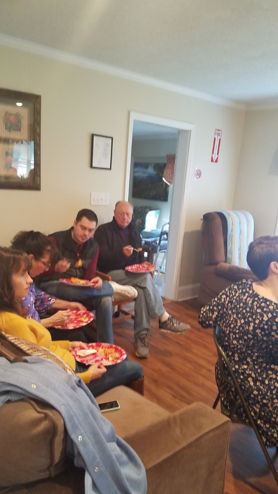 A group of people sitting together indoors, enjoying a meal.