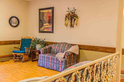 A cozy living room setup featuring a patterned sofa, a rocking chair, and decorative elements.