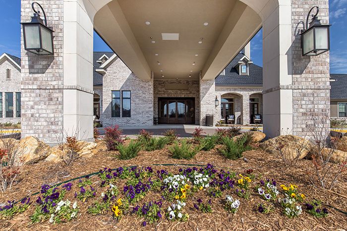 A modern building entrance with landscaped flower beds.