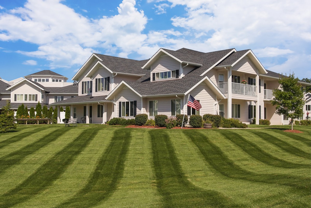 A large house with a beautifully manicured lawn and clear sky.