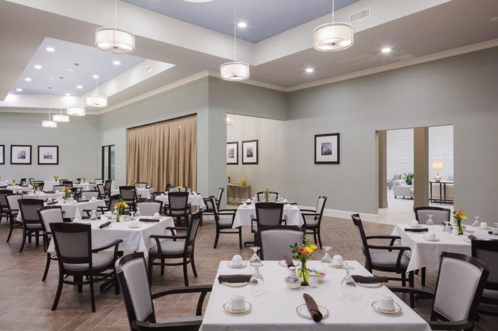 A spacious dining room with neatly arranged tables and chairs, featuring a formal and elegant interior design.