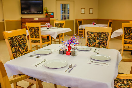 A cozy dining area set up for a meal, featuring neatly arranged tables and decorative elements.