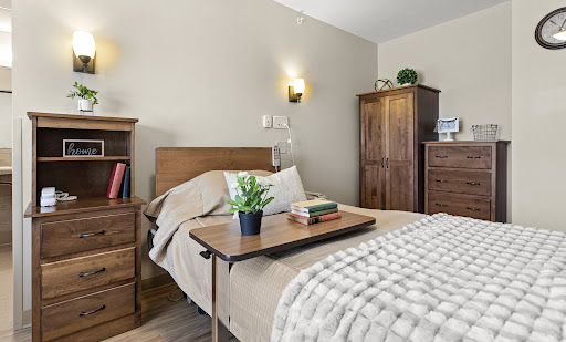 A cozy bedroom featuring wooden furniture, a neatly made bed, and decorative elements for a warm atmosphere.