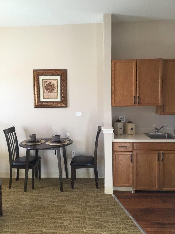 A small kitchen with a dining table set for two.