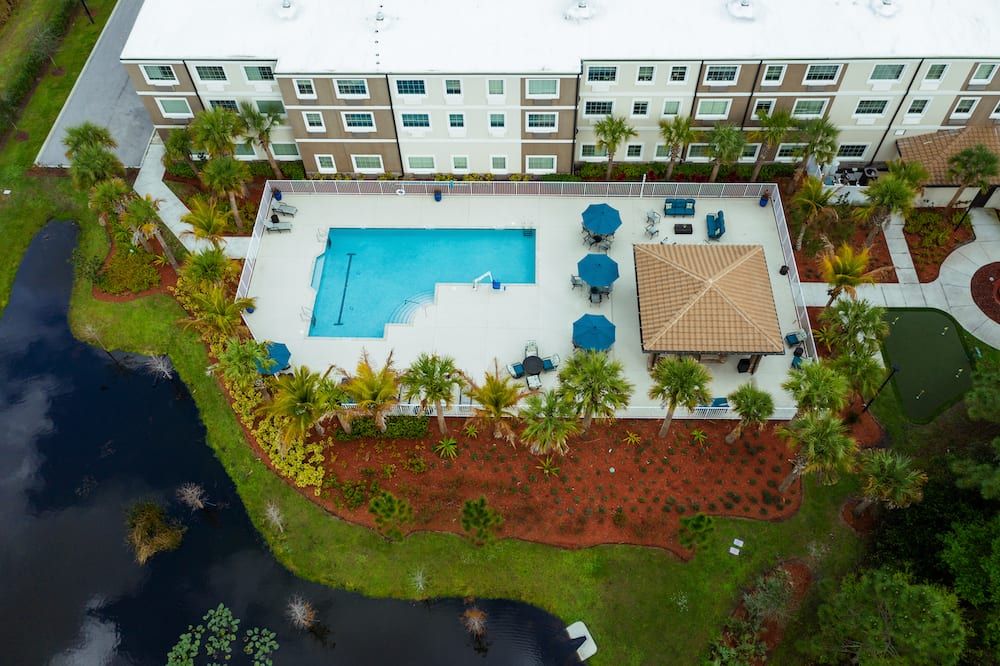 Aerial view of an apartment complex with a swimming pool and outdoor seating area.