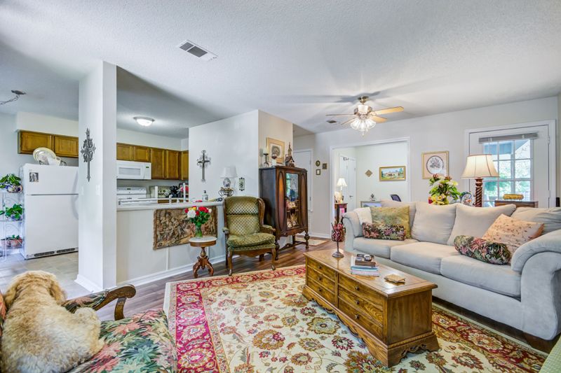 A cozy living room with traditional decor, featuring a comfortable sofa, patterned carpet, and wooden coffee table.