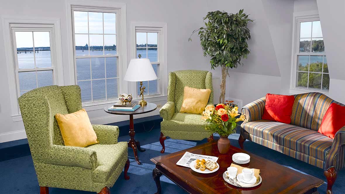A cozy living room with armchairs and a coffee table by the window.
