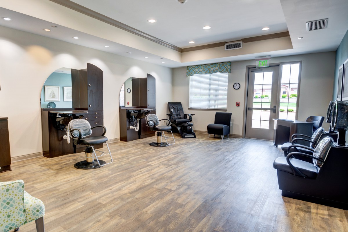 A modern, empty hair salon with stylish chairs and mirrors.