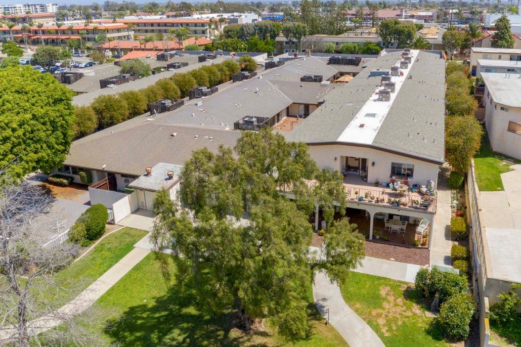 Aerial view of a building surrounded by trees and pathways in a neighborhood setting.
