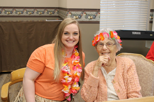 A joyful moment shared between a young woman and an elderly lady, both enjoying a festive occasion.