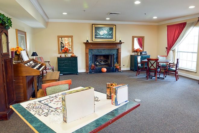 A cozy living room featuring a fireplace, comfortable seating, and decorative artwork.
