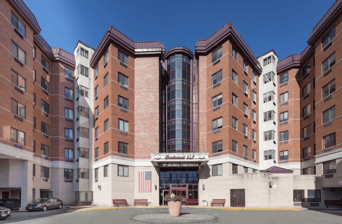 A multi-story building with a prominent entrance, likely serving as a hotel or apartment complex.