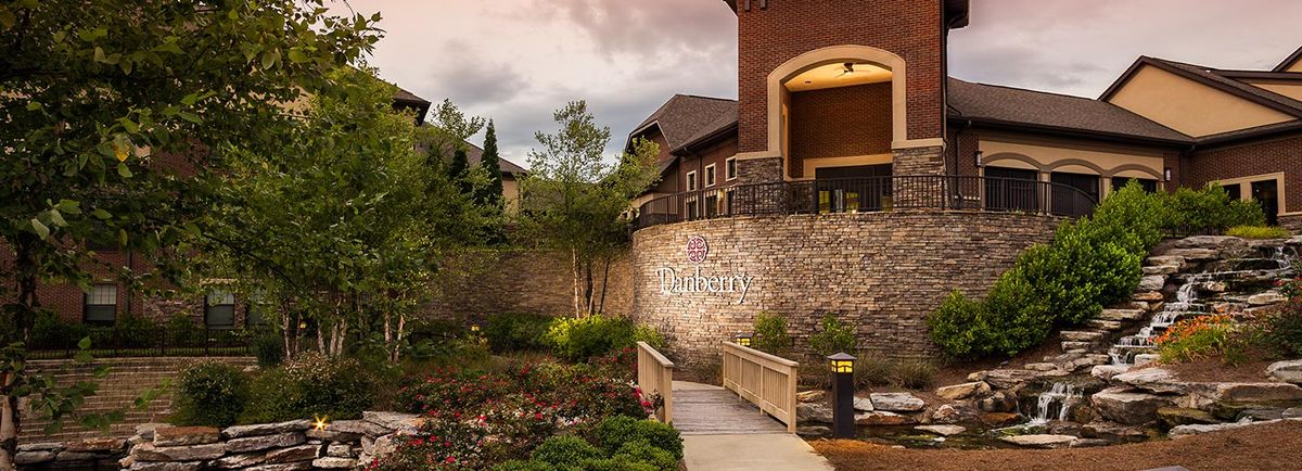 A scenic view of a building with a stone wall and landscaped gardens.