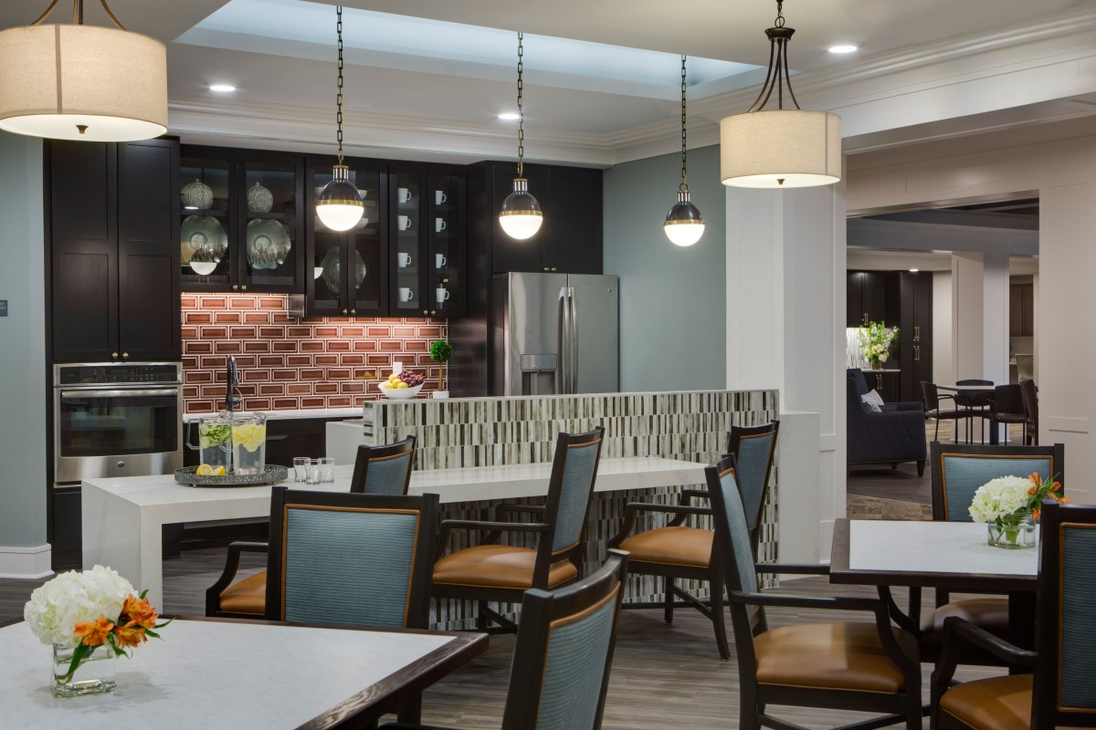 A modern kitchen and dining area featuring pendant lights, a countertop, and stylish chairs.