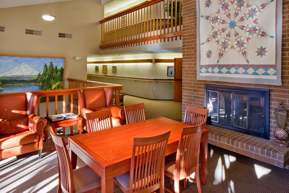 A cozy dining area with wooden furniture and a fireplace, featuring warm lighting and decor.