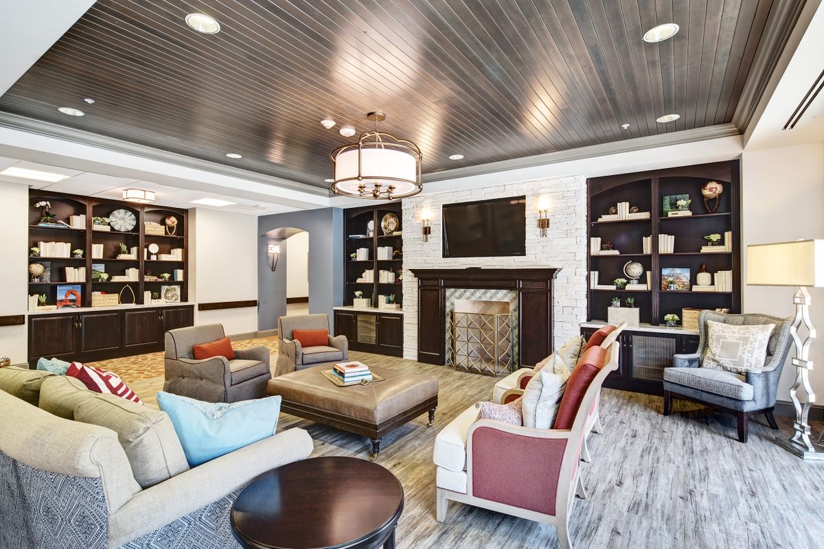 A stylish and cozy living room featuring comfortable seating, a fireplace, and well-decorated shelves.