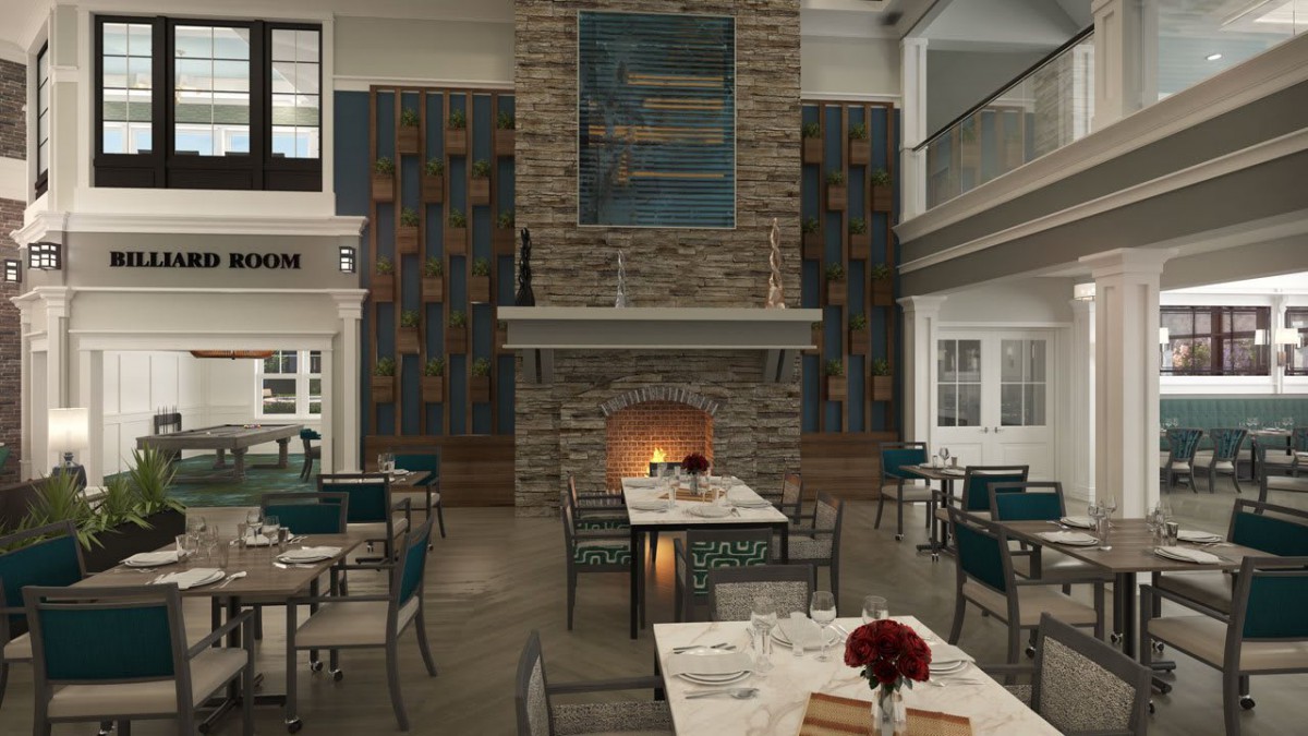 A cozy restaurant interior featuring a central stone fireplace surrounded by dining tables and modern decor.