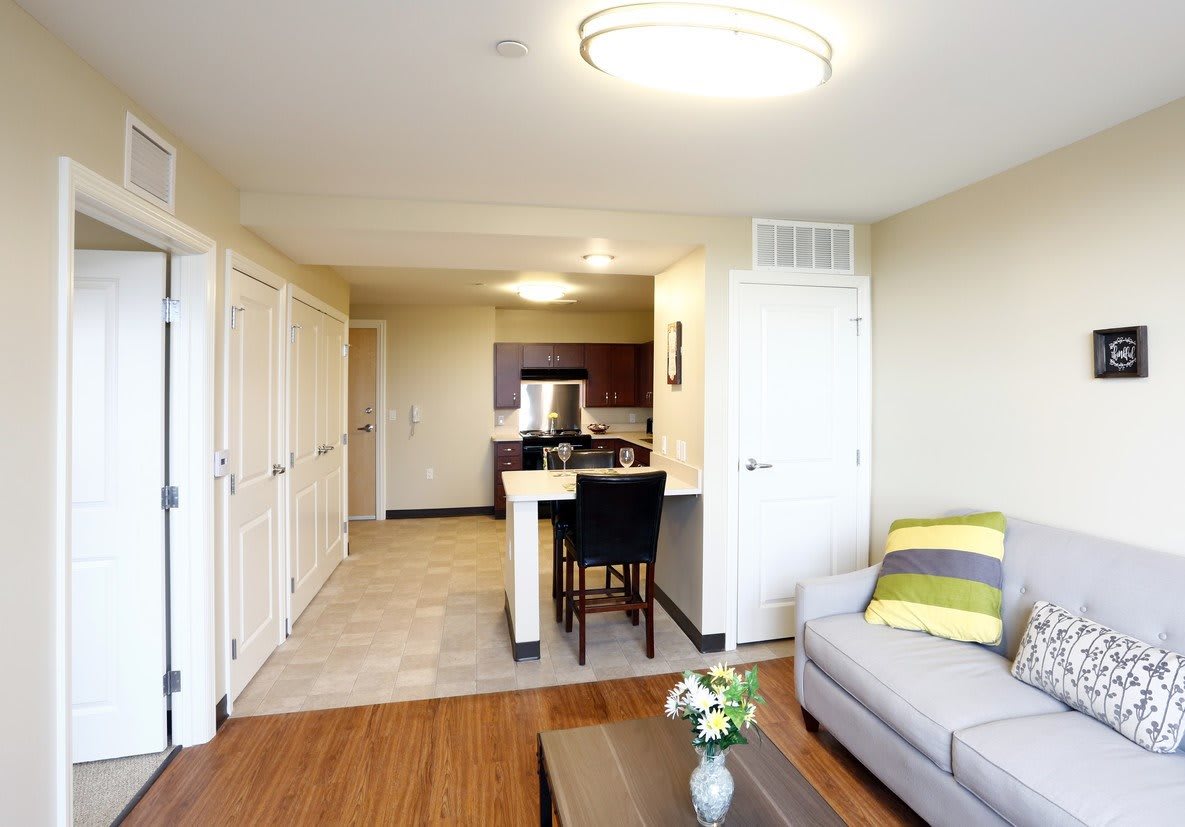 A modern open-concept apartment with a view from the living room towards the kitchen.