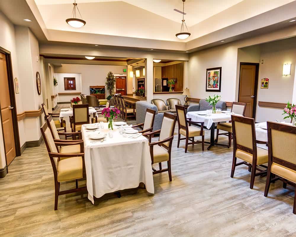 A well-arranged dining area with neatly set tables and chairs, showcasing a clean and inviting interior design.